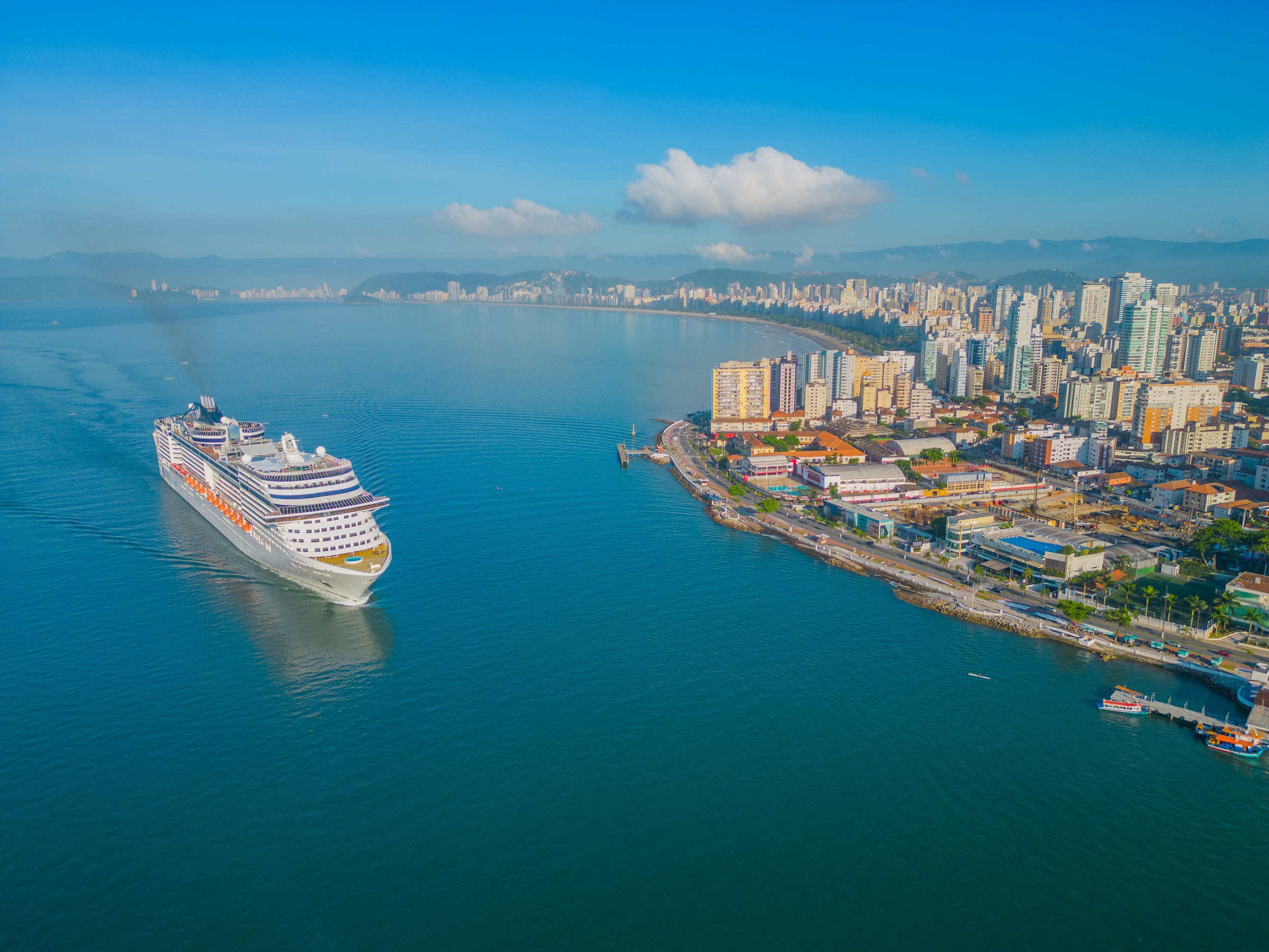 Vista aérea do canal do Porto de Santos com um navio entrando e a orla da cidade
